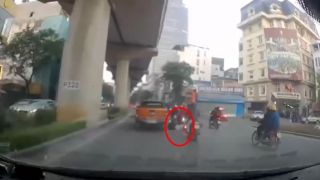 Camera ghi lại cảnh xe máy lạng lách, phanh gấp, trượt ngã vào gầm ô tô, bất tỉnh trên đường ở Hà Nội