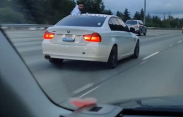 Trời nóng, tài xế BMW 3-Series vừa lái xe vừa ngồi trên cửa sổ để hóng mát