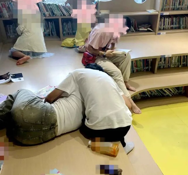cap-doi-om-ap-hon-nhau-tai-khu-vuc-doc-sach-danh-cho-thieu-nhi-trong-mot-thu-vien-gay-buc-xuc