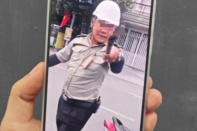 nguoi-dan-ong-mac-ao-bao-ve-chan-dau-o-to